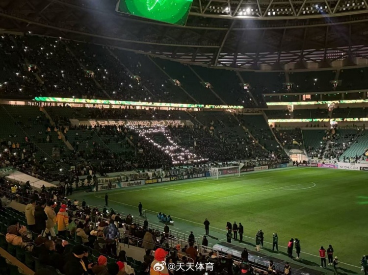 亚冠二国安对麦克阿瑟赛前，北看台球迷用手电筒拼出冠军奖杯造型